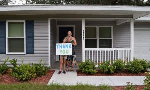 Homeowner with daughter outside new house