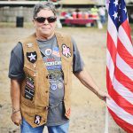 veterans village ground breaking patron holding american flag