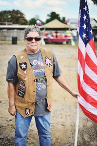 veterans village ground breaking patron holding american flag