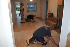 volunteers laying flooring inside a preservation and repair project