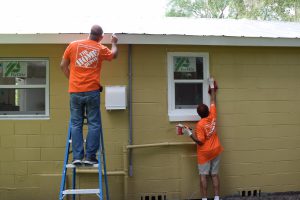 Home Depot volunteers painting exterior of house