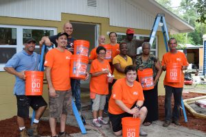 Group photo with Home Depot volunteers, homeowner, family, and Habitat staff