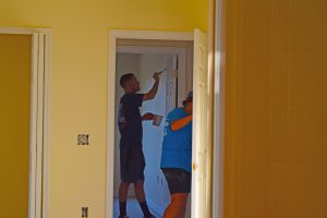 volunteers painting interior house of the Veterans Village