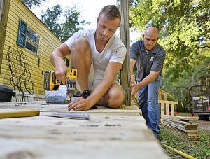 Enzo Cosani, of Paris, France, and Travis Wofford, a construction specialist for Habitat for Humanity, work April 24 on a wheelchair ramp at a home in Summerfield. Cosani is part of the international intern program for Habitat for Humanity. Bill Mitchell, Daily Sun