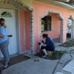 preservation and repair volunteers painting front of the house