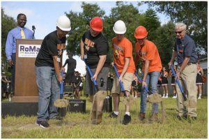 Construction Academy students alongside Dan Robuck Sr. grab a shovel of dirt at the Habitat for Humanity and Leesburg High Construction Academy groundbreaking ceremony in Leesburg on Monday. [Cindy Sharp/Correspondent]