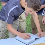Student signing bible that will be gifted to future homeowner