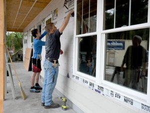 Under the direction of instructor Bruce Haberle, reflected right, The Villages High School Construction Management Academy seniors David Routzahn, 17, and Trey Jones, 19, make chalk lines for the siding on a Habitat for Humanity house Tuesday in Lady Lake. Photos by Cindy Skop, Daily Sun