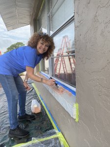 Diane Treadway, president of Leesburg Evening Rotary Club, does exterior painting on a Leesburg home as part of Habitat for Humanity’s Preservation and Repair Program.