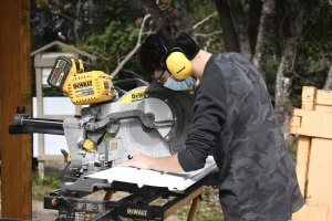 Leesburg High School Youth Academy student using saw outside