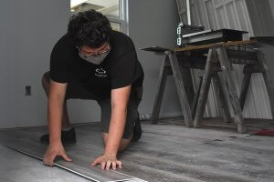 Leesburg High School Youth Construction Academy student working on flooring