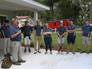 Instructor Bruce Haberle congratulates students with The Villages High School’s Construction Management Academy for helping build a new home in Lady Lake for Amanda Brooks and her daughter, Emilee Carter.