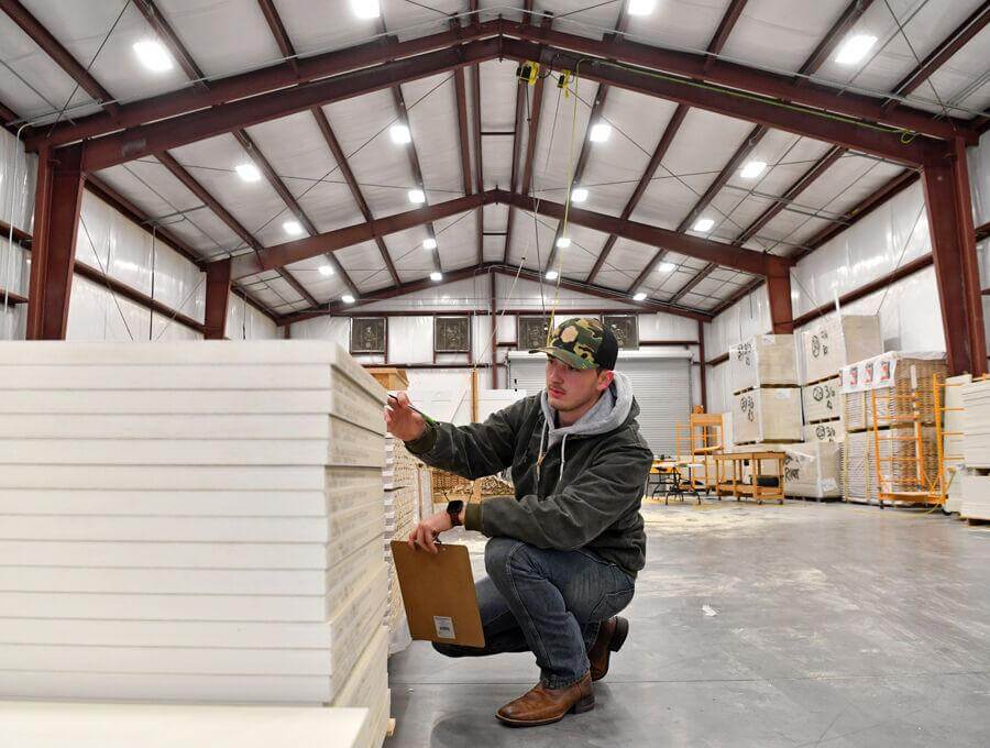 Adam Hatfield, a 2020 graduate of The Villages High School, takes inventory of doors at MiCo Customs at the Gov. Rick Scott Industrial Park. Hatfield learned marketable job skills in the VHS Construction Management Academy.  Rachel Stuart, Daily Sun