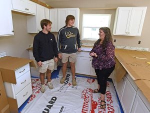 Debbie Duket, right, learns about her new cabinets from members of The Villages High School Construction Management Academy Jake Phillips, left, and Brady Widmann, who are helping to build her Habitat for Humanity home in Wildwood. George Horsford, Daily Sun