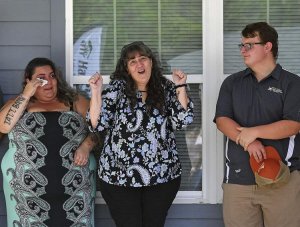 Victoria Duket, left, wipes her tears as her mother, Debbie Duket celebrates alongside Aidan Campbell, a VHS Construction Management Academy student, during the their new home’s dedication ceremony. With help from Habitat for Humanity of Lake-Sumter, students built the house. Rachel Stuart, Daily Sun